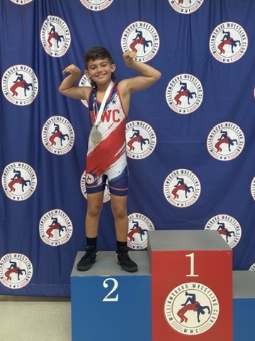 WWC wrestler flexing on the podium