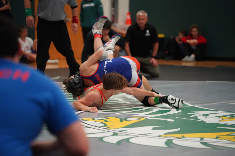 A referee watching a match on the mat